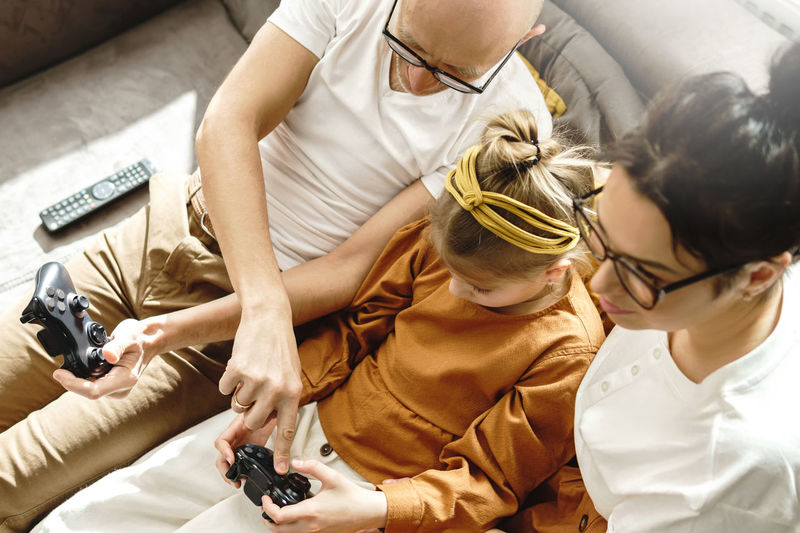 High angle view of father teaching daughter playing game at home