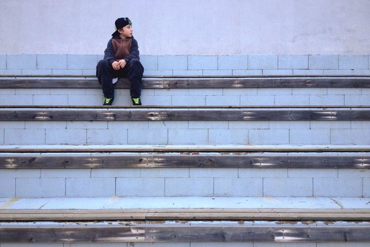Boy sitting on staircase