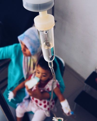 Woman sick child with iv drip at hospital