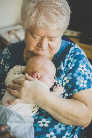 Grandmother holding her sleeping baby granddaughter