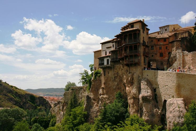 Hanging houses of cuenca against cloudy sky during sunny day
