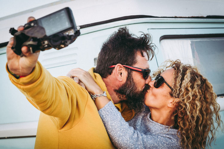 Mature couple kissing while taking selfie 