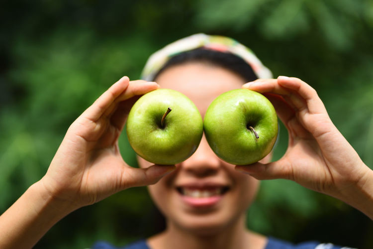 Close-up of woman with eyes covered by apples
