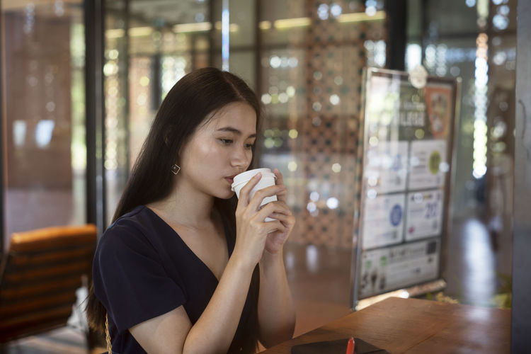 Woman drinking coffee in restaurant