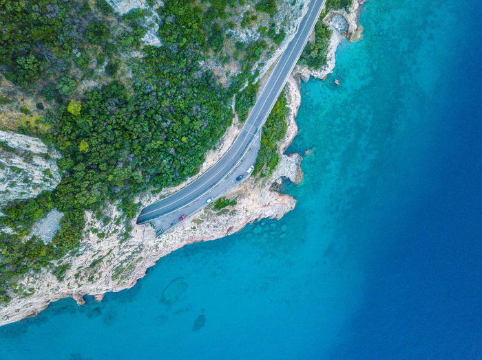 Aerial view of road amidst sea and trees