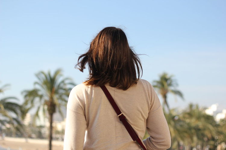 Rear view of woman standing against sky