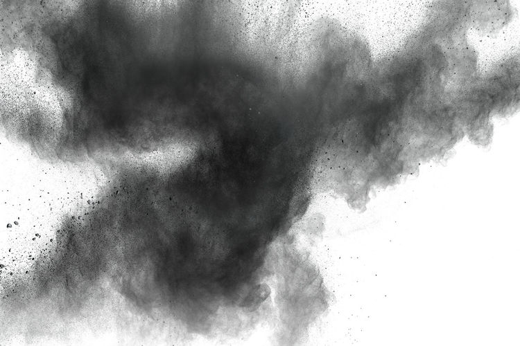 Defocused image of black powder paints against white background
