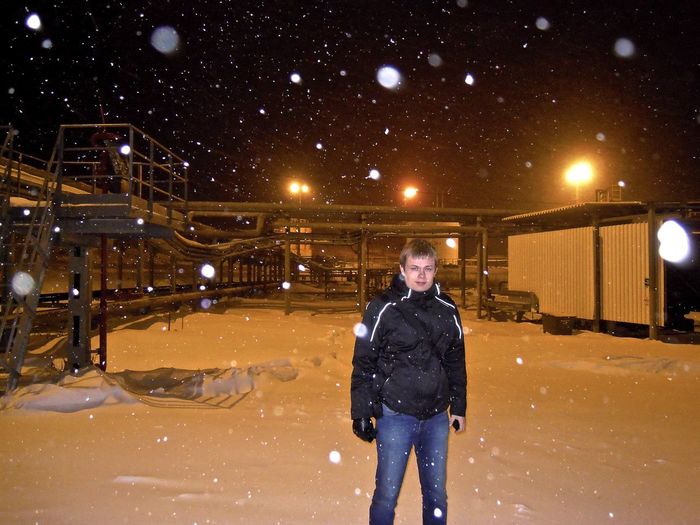Portrait of man standing in snow covered land during winter at night