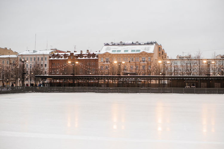 Cityscape of winter city view with christmas decoration and colorful house buildings with ice rink 