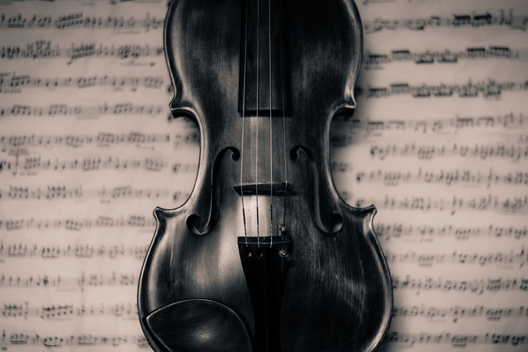 Close-up of violino againt open sheet music 