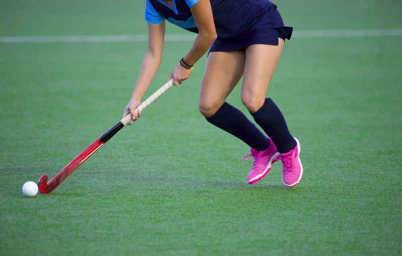 Low section of woman playing hockey in court