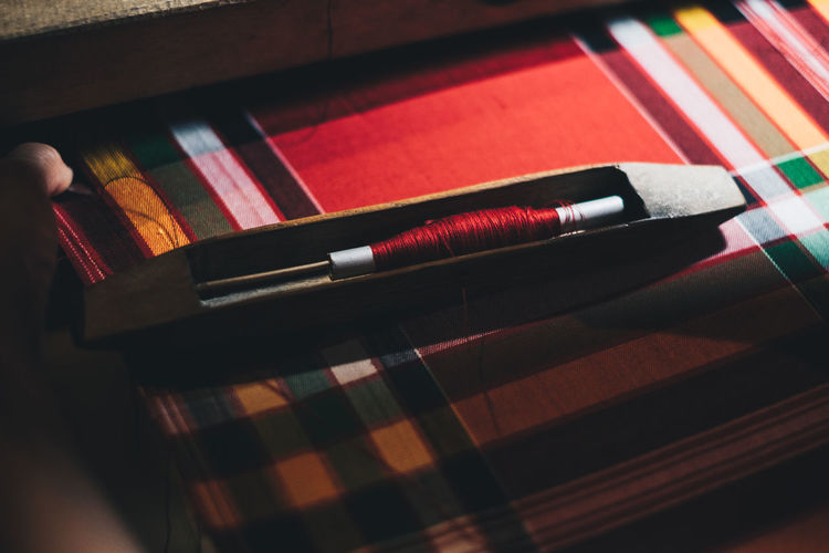 High angle view of sewing item on colorful textile