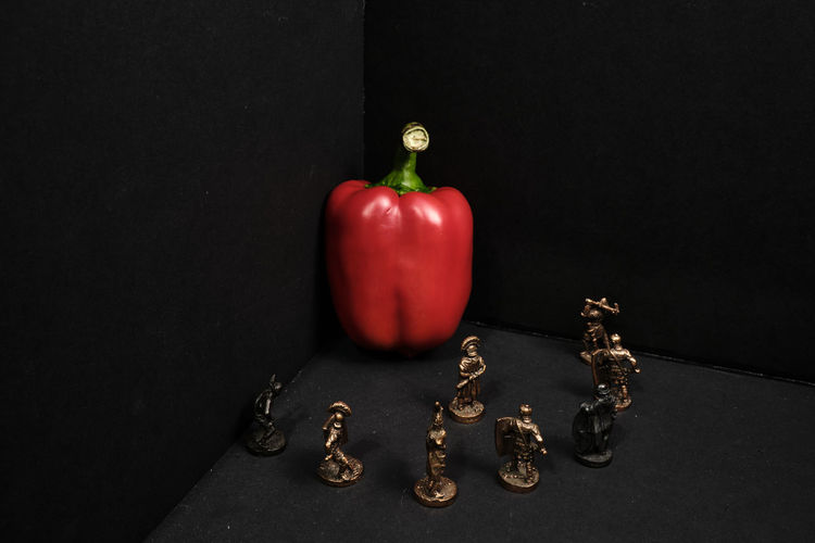 Close-up of bell peppers on table against black background