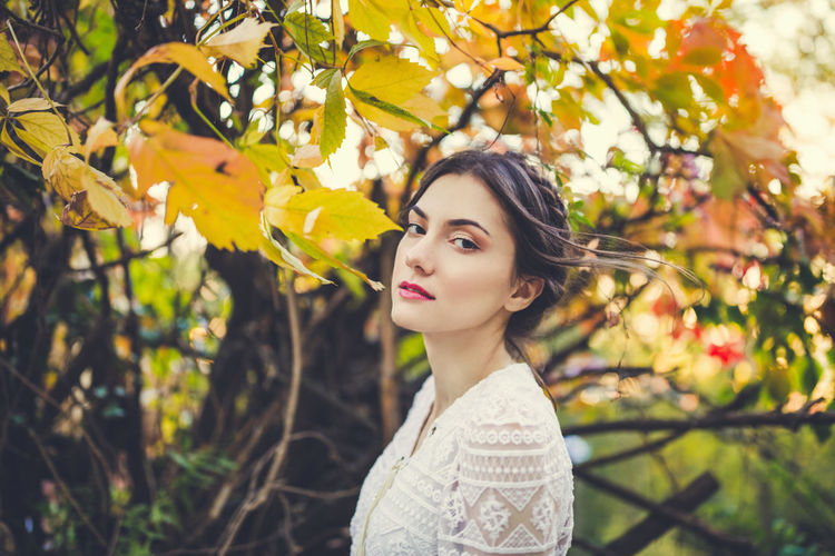 Beautiful young woman in a white lace blouse in an autumn park. fall season 