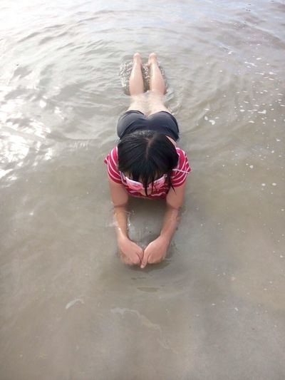 High angle view of teenager lying on shore