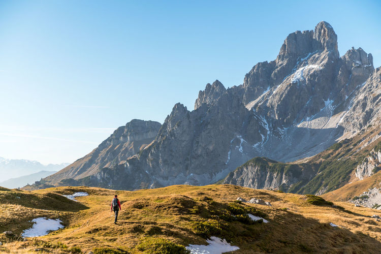 Woman hiking on footpath in alpine landscape, bischofsmütze, filzmoos, austria