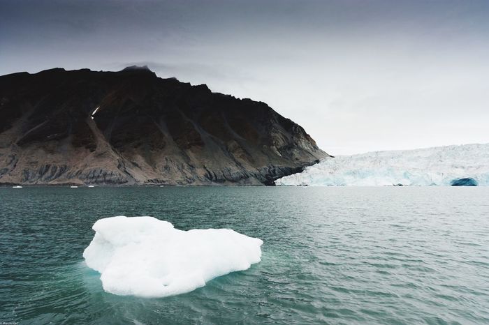 Close-up of iceberg on lake against mountain