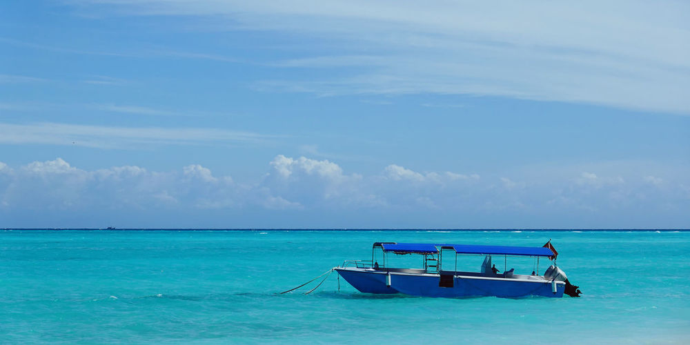 Fishing boat in sea against sky
