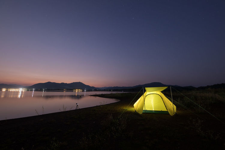 Scenic view of lake against clear sky at night