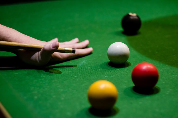 Cropped hand playing pool at table