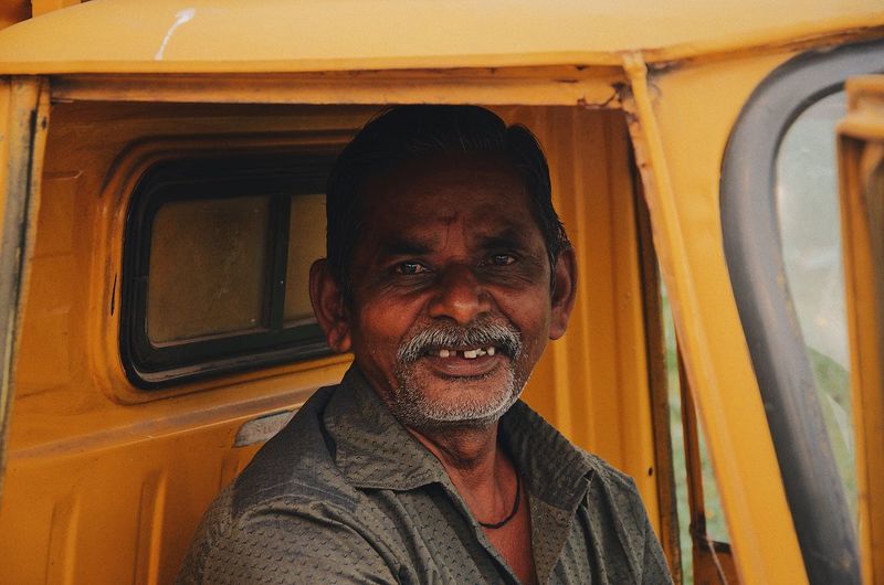 Close-up portrait of smiling mature man sitting in jinriksha