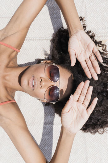 Woman wearing sunglasses sunbathing at beach