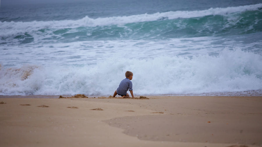 Rear view of man walking on beach