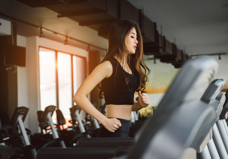 Side view of young woman exercising in gym