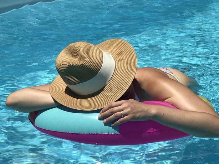 Midsection of woman sitting in swimming pool