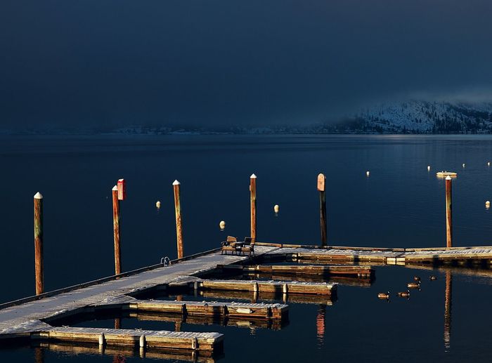 Pier at lake against sky during dusk