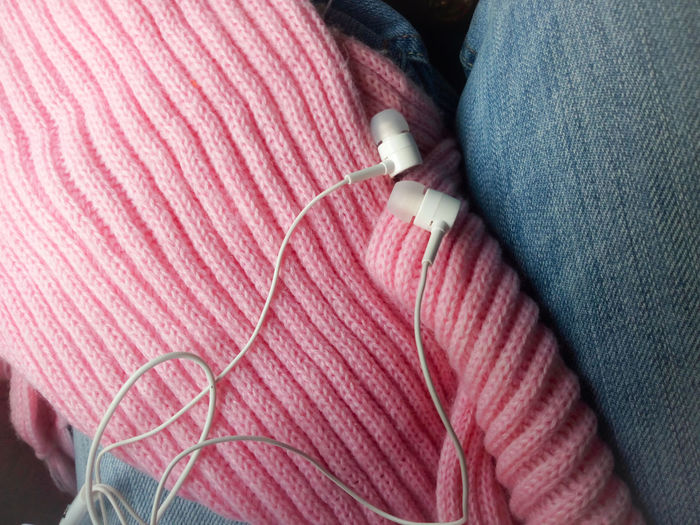 Close-up of in-ear headphones on woman laps