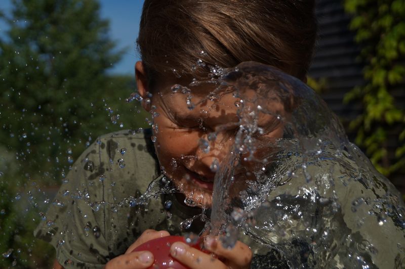 Boy is getting hit by water balloon