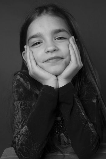 Portrait of smiling girl against black background