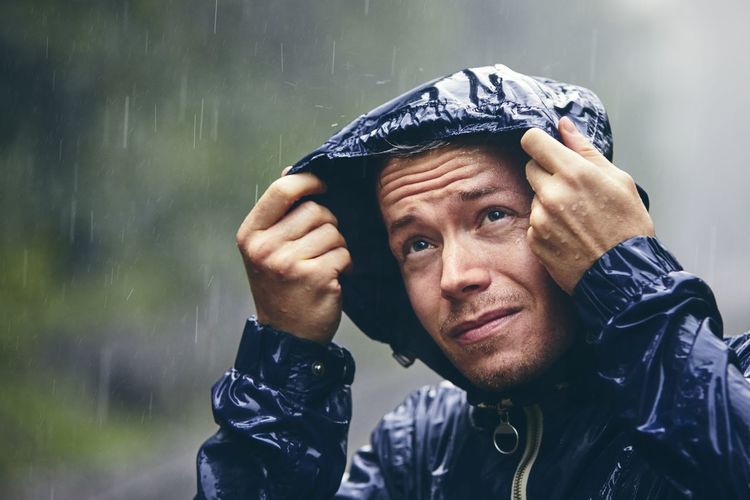 Man wearing raincoat during rainy season