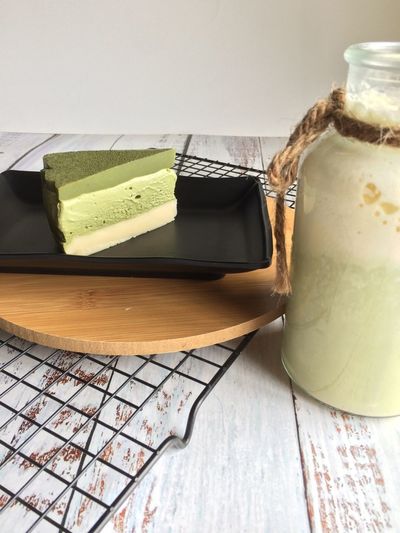 No-bake matcha cheesecake with green tea on black plate for high tea 