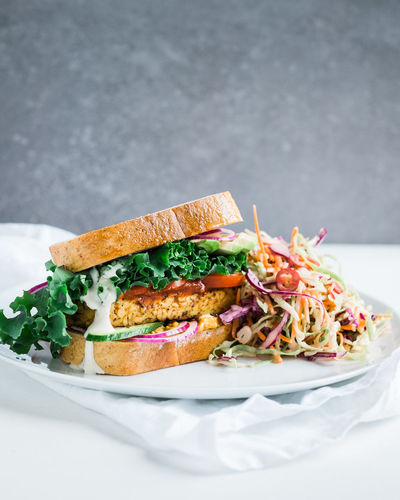 Tempeh and kale sandwich with chili coleslaw on table