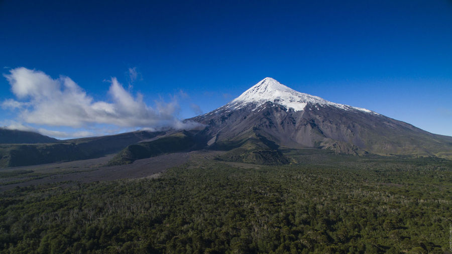 Scenic view of snowcapped mountains against blue sky