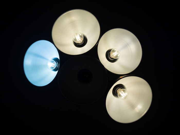 Directly below shot of illuminated light bulb against black background