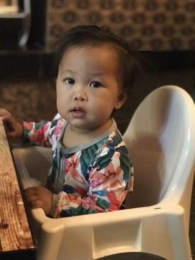 Portrait of cute baby girl sitting in kitchen