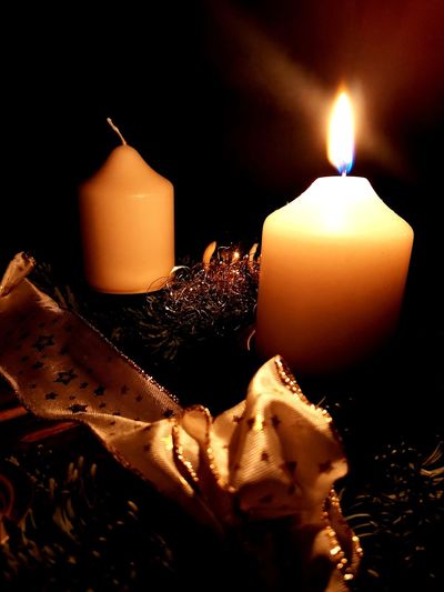 Close-up of illuminated candle against black background