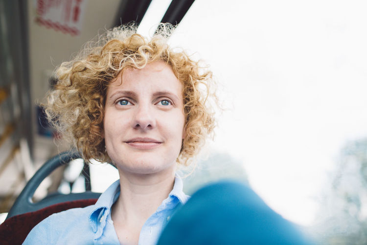 Portrait of smiling young woman in bus
