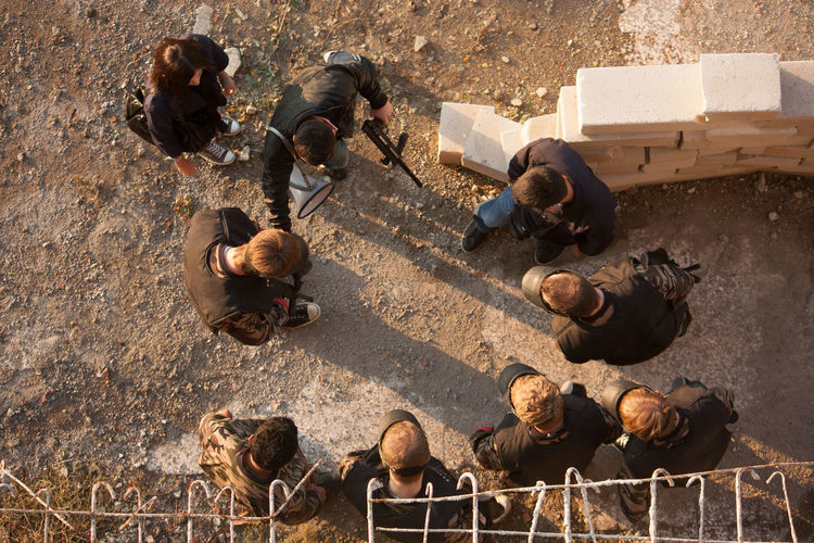 Directly above shot of paintball players preparing and planning game on field
