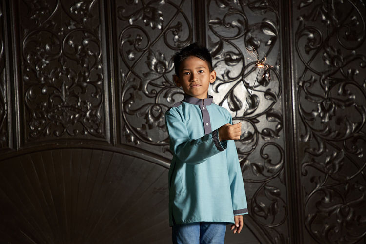 Malay boy playing fireworks sparkler during ramadan festival 