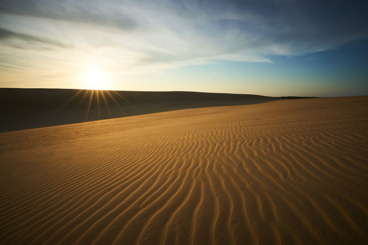 Scenic view of desert against sky during sunset