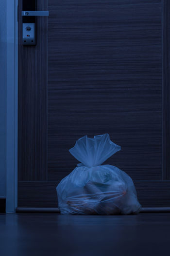 Garbage bag on room floor at night time, to be moved out, waste pollution and environment concept