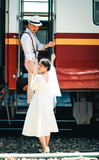 Rear view of couple standing on train