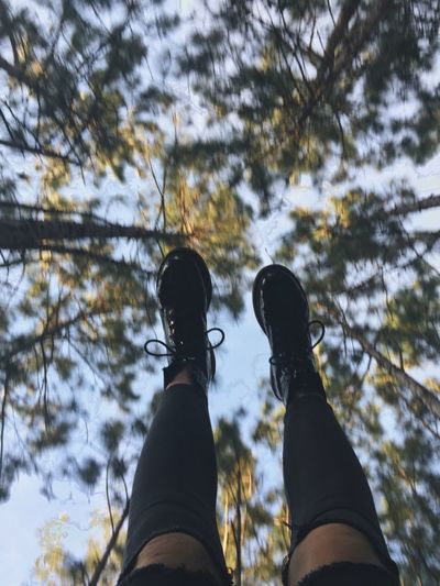 Low angle view of human feet against clear sky