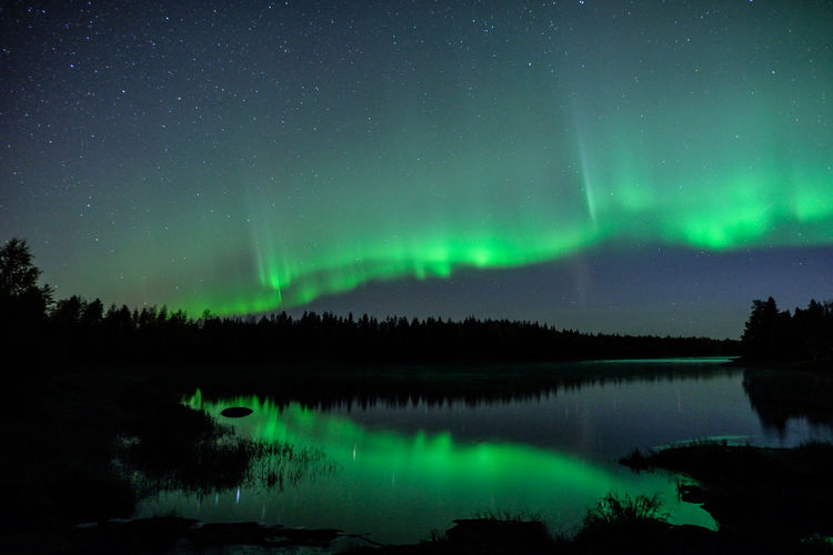 Scenic view of lake against sky at night