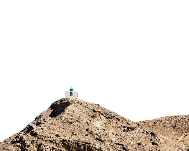 Low angle view of man climbing on mountain against clear sky