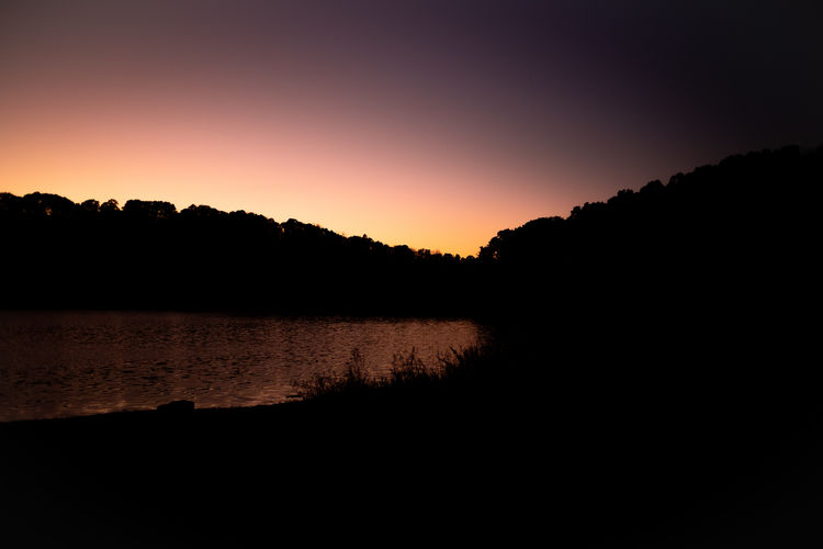 Scenic view of lake against orange sky